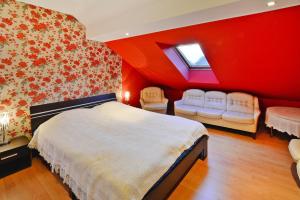 a bedroom with red walls and a bed and chairs at Comfortable house by the lake, Insko in Ińsko