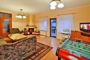 a living room with a pool table and a tv at Comfortable house by the lake, Insko in Ińsko