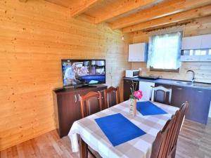 a kitchen and dining room with a table and a television at Holiday resort, Jaroslawiec in Jarosławiec