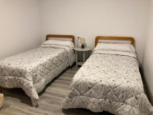 two beds sitting next to each other in a bedroom at Apartamento Turístico Cervantes 18 in Losar de la Vera
