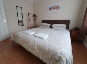 um quarto com uma cama grande com duas toalhas em Friars Walk 2 with 2 bedrooms, 2 bathrooms, fast Wi-Fi and private parking em Sittingbourne