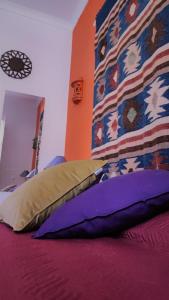 a bedroom with a bed with purple sheets and a pillow at Santo António's Guesthouse in Cascais