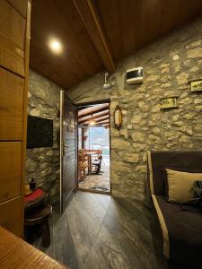 Habitación con pared de piedra, cama y mesa. en Apartman Sofranac en Rijeka Crnojevića