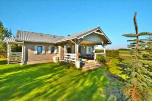 a small house on a green lawn with a tree at Comfortable holiday home with a private garden in Oswino