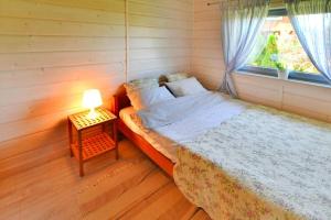 1 dormitorio con 1 cama con lámpara y ventana en Comfortable holiday home for 8 people, Oswino, en Oswino
