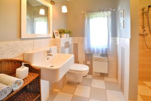 a bathroom with a white sink and a toilet at Comfortable holiday home with a private garden in Oswino +21 photos