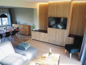 a living room with a couch and a tv at Villa Calmeyn in De Panne