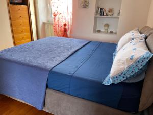 ein Bett mit blauer Decke in einem Schlafzimmer in der Unterkunft LE SOLEIL DOREE' MAISON Wi-Fi VACATIONS LERICI 5 TERRE in Pitelli