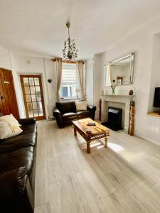 uma sala de estar com um sofá e uma mesa de centro em Ty-Nance Cottage em Caerphilly