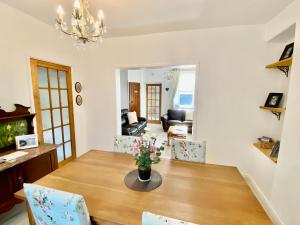 uma sala de jantar com mesa e cadeiras em Ty-Nance Cottage em Caerphilly