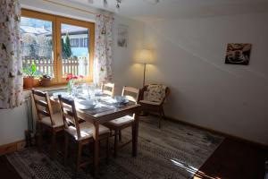 comedor con mesa, sillas y ventana en Am Jenbach, en Bad Feilnbach