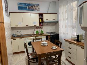 a kitchen with a table and a sink and a stove at La Maison di Francesco in Genova