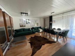 een woonkamer met een groene bank en een tafel bij Apartment am Wasserfall - Erholung in Top-Lage in Feldberg