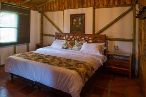 1 dormitorio con 1 cama grande en una habitación en Hacienda Charrascal Coffe Farm, en Manizales