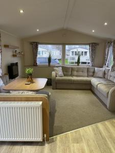 a living room with a couch and a table at Coastal retreats, Beech rise, primrose valley in Filey