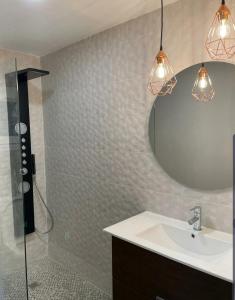 ein Bad mit einem Waschbecken, einem Spiegel und einer Dusche in der Unterkunft Louti's apartment in La Pineda