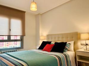 1 dormitorio con 1 cama con 2 almohadas rojas en Apartamento Europa Prados - Atenea, en Oviedo