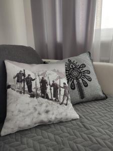a pillow on a bed with a picture on it at Retrospekcja - Apartament w centrum in Zakopane