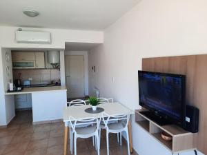 eine Küche und ein Wohnzimmer mit einem Tisch und einem TV in der Unterkunft Monoambiente Rivadavia in Cipolletti