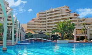 basen przed dużym budynkiem w obiekcie Seaview beachfront studio with aqua park & balcony w mieście Benalmádena