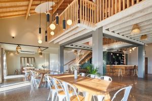 a dining room with wooden tables and white chairs at Domaine Etxezahar in Bardos