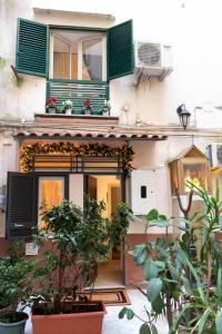 a building with green shutters and a balcony with plants at Yes I Know My Room - Magica Napoli in Naples