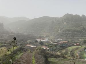 un pueblo en un valle con montañas en el fondo en Finca El cole, en Las Palmas de Gran Canaria