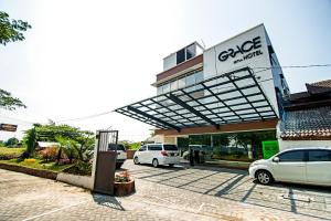 a car dealership with cars parked in a parking lot at Grace Setia Hotel in Surabaya
