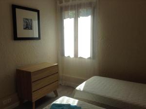 a bedroom with a bed and a dresser and a window at LA CASA in Cagnes-sur-Mer