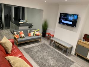 a living room with a couch and a flat screen tv at Beautiful 5 Bedrooms house, free parking & Wifi Corporate, Contractors, Family relocation, CONTACT US FOR LONG TERM RATE in Dartford