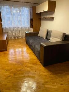 a living room with a black couch and a wooden floor at Apartment on Pechersk in Kyiv