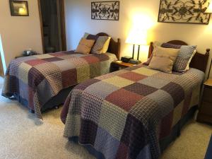 a bedroom with two beds and a lamp at Pinehaven Country Inn in Baraboo