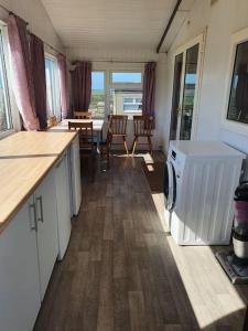 a kitchen with a washer and dryer in a house at On farm Chalet, sleeps 6, Rhoshirwaun in Aberdaron