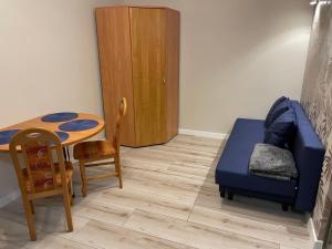 a room with a table and a bed and a table and chair at Apartament Puscha in Kielce