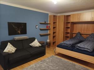 ein Wohnzimmer mit einem Sofa und einem Bett in der Unterkunft The Deer's Den in Garmisch-Partenkirchen