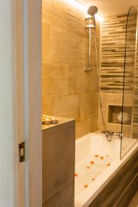 Das Bad ist mit einer Badewanne und einer Dusche ausgestattet. in der Unterkunft Dealhouse Apartments 1 in Huddersfield