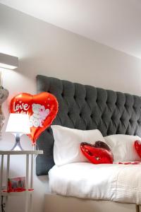 ein Bett mit zwei roten Kissen und einem Herzballon in der Unterkunft Dealhouse Apartments 1 in Huddersfield