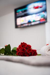ein Strauß roter Rosen vor einem Fernseher in der Unterkunft Dealhouse Apartments 1 in Huddersfield