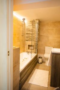 a bathroom with a tub and a toilet at Dealhouse Apartments 1 in Huddersfield