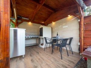 a patio with a table and chairs and a refrigerator at Pipacsos Vendégházak in Kiskunmajsa