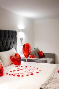 Schlafzimmer mit roten Herzen auf dem Bett in der Unterkunft Dealhouse Apartments 1 in Huddersfield