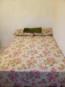 1 cama con colcha floral en el dormitorio en Canadian Standard Villa Guesthouse, en Montego Bay