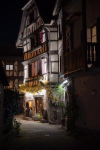 um edifício antigo à noite com luzes acesas em Calme et cosy em Obernai