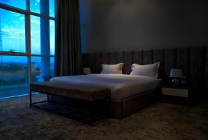 a bedroom with a large bed with a large window at فندق راديانس جراند in Abha