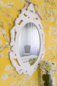 a mirror on a wall with a chair in a room at Pensión Ferradura in Melide