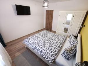 a bedroom with a bed and a flat screen tv at Perfect Stay Apartment Petrosani in Petroşani