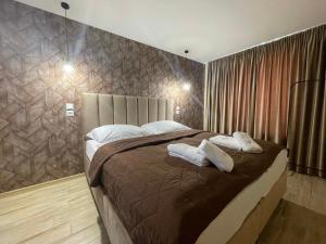 a bedroom with a large bed with two pillows at Totina Apartments in Závažná Poruba
