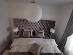 - une chambre avec un grand lit et deux lampes dans l'établissement Apartman PIKY No.10, à Moravske Toplice