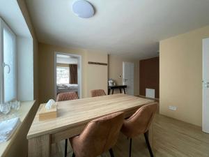 a dining room with a wooden table and chairs at Totina Apartments in Závažná Poruba