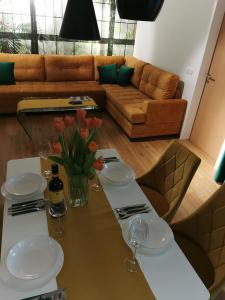 uma sala de estar com uma mesa com copos de vinho e um sofá em Apartman PIKY No.10 em Moravske Toplice
